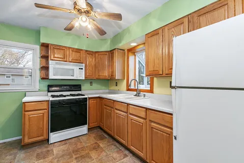 a kitchen with kitchen island granite countertop a sink stainless steel appliances and cabinets