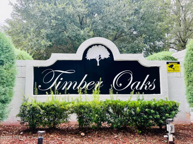 a front view of a house with sign board and garden