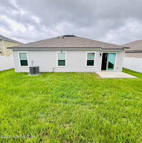 a front view of house with yard and trees in the background