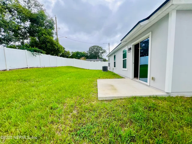 a view of a house with a yard and sitting area