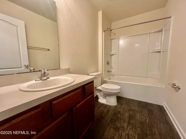 a bathroom with a sink a toilet and a large mirror