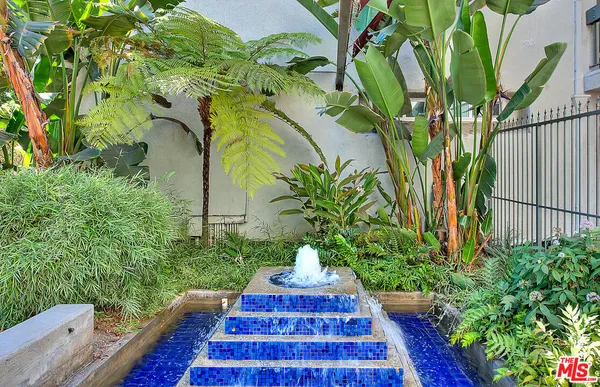 a view of a yard with plants and trees