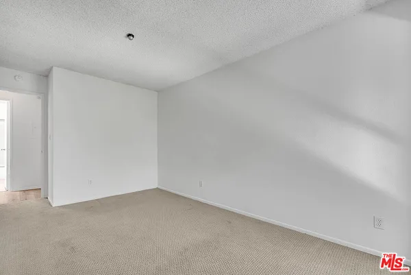 an empty room with chandelier fan and windows