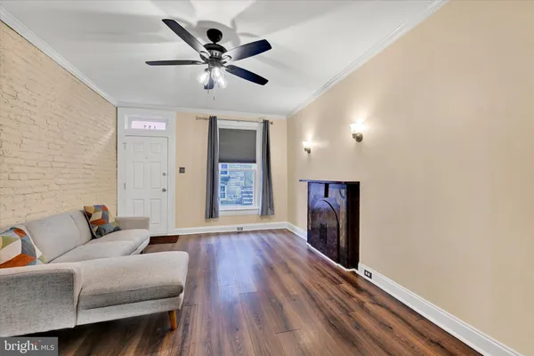 a living room with furniture and a ceiling fan