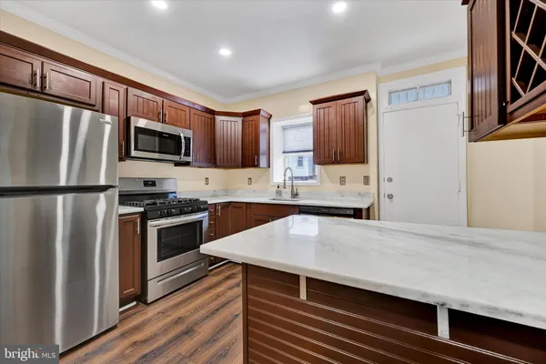a kitchen with stainless steel appliances a stove refrigerator sink and microwave