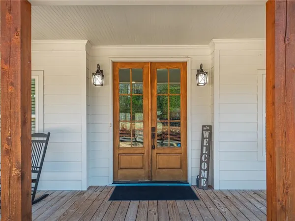 a large kitchen with stainless steel appliances kitchen island granite countertop a refrigerator a stove a sink and a dining table with wooden floor