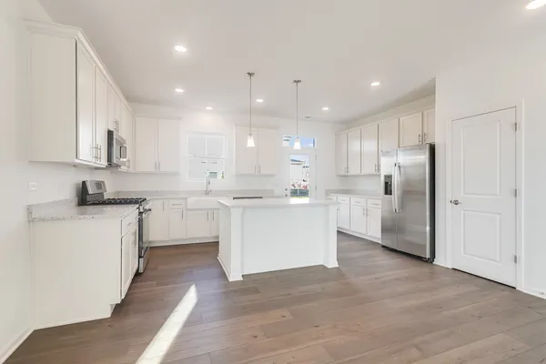 a kitchen with white cabinets and refrigerator