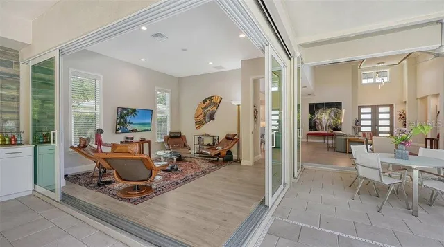 a living room with patio furniture and a large window