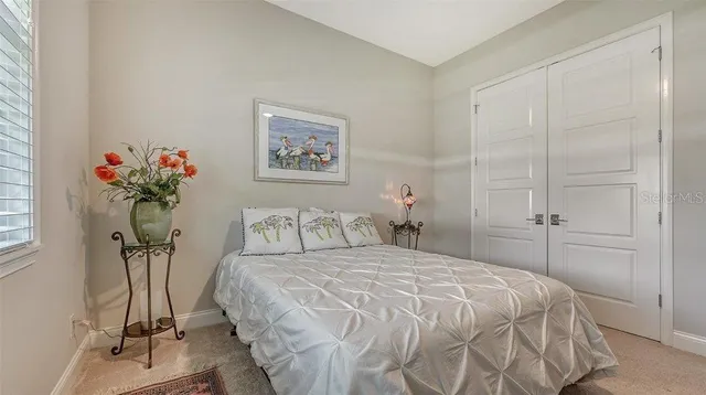 a bedroom with a bed and a potted plant