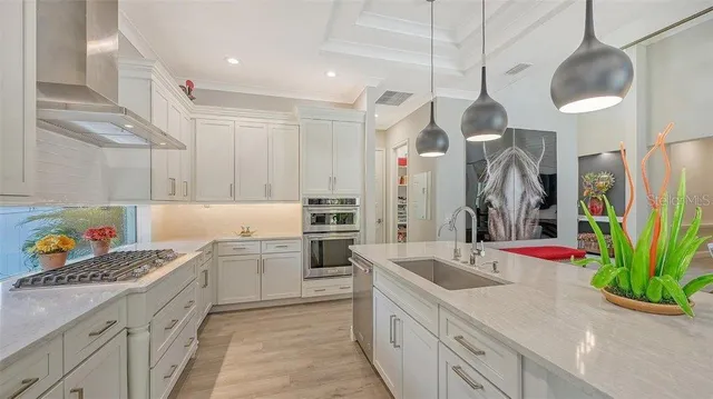 a kitchen with stainless steel appliances kitchen island granite countertop a sink and a refrigerator