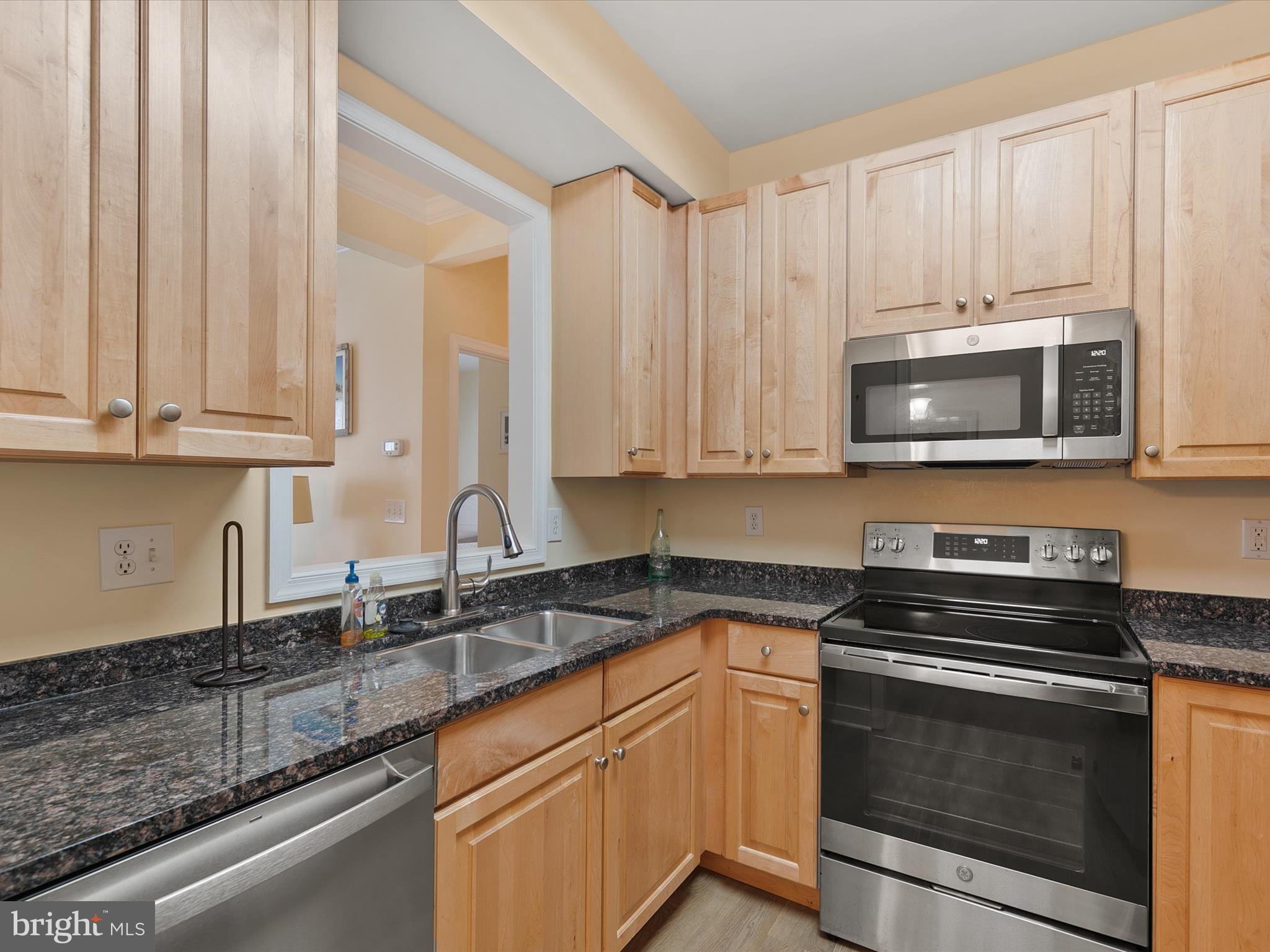 30611 Cedar Neck Road, Unit 2204 Ocean View, DE 19970 - Photo 11 of 33 a kitchen with stainless steel appliances granite countertop a sink a stove a microwave and cabinets