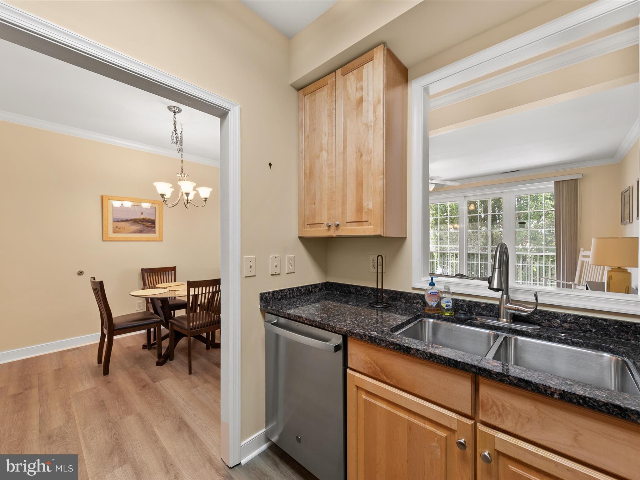 30611 Cedar Neck Road, Unit 2204 Ocean View, DE 19970 - Photo 13 of 33 a kitchen with granite countertop a sink and white cabinets