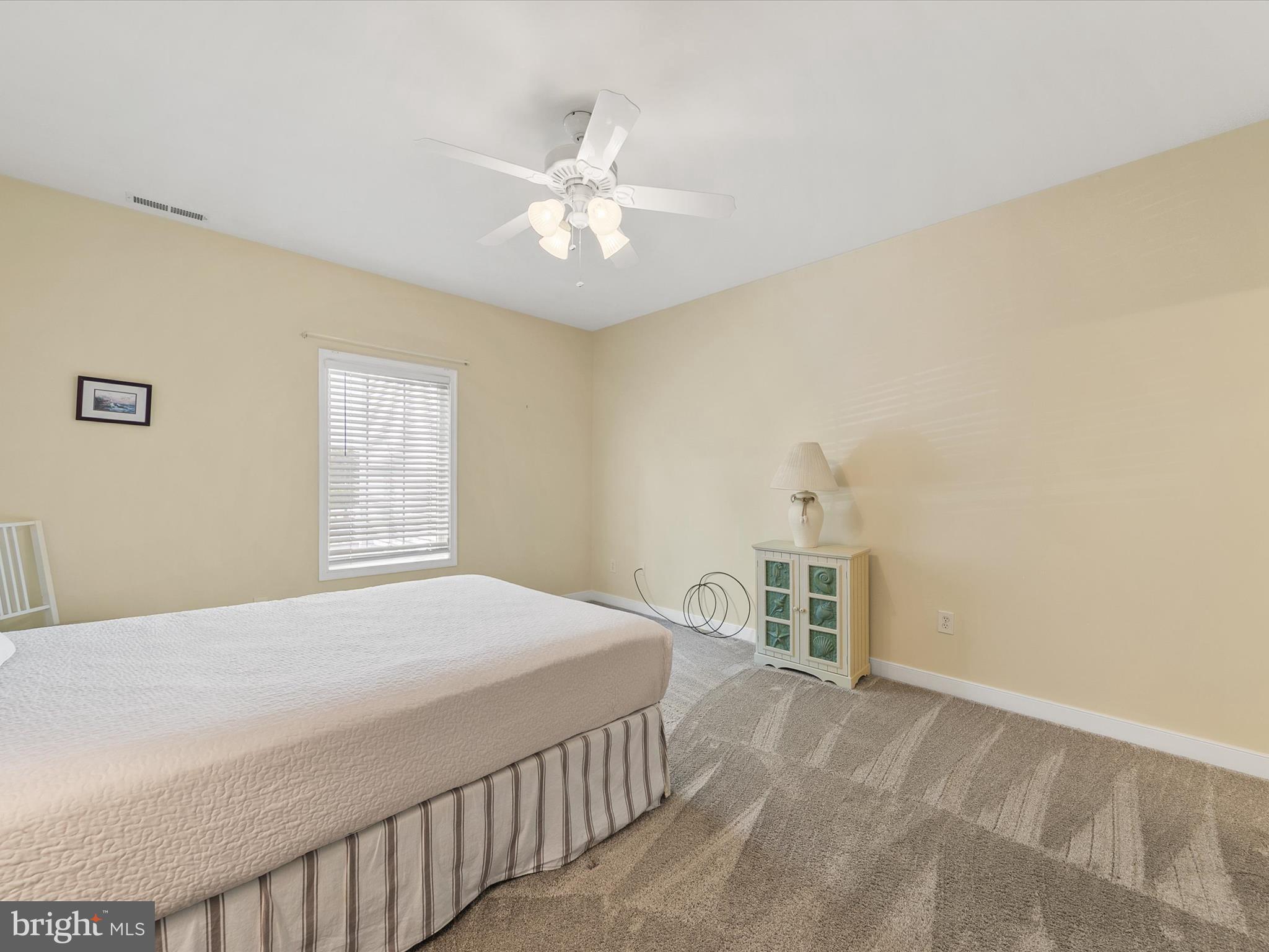 30611 Cedar Neck Road, Unit 2204 Ocean View, DE 19970 - Photo 15 of 33 a bedroom with a large bed and a window