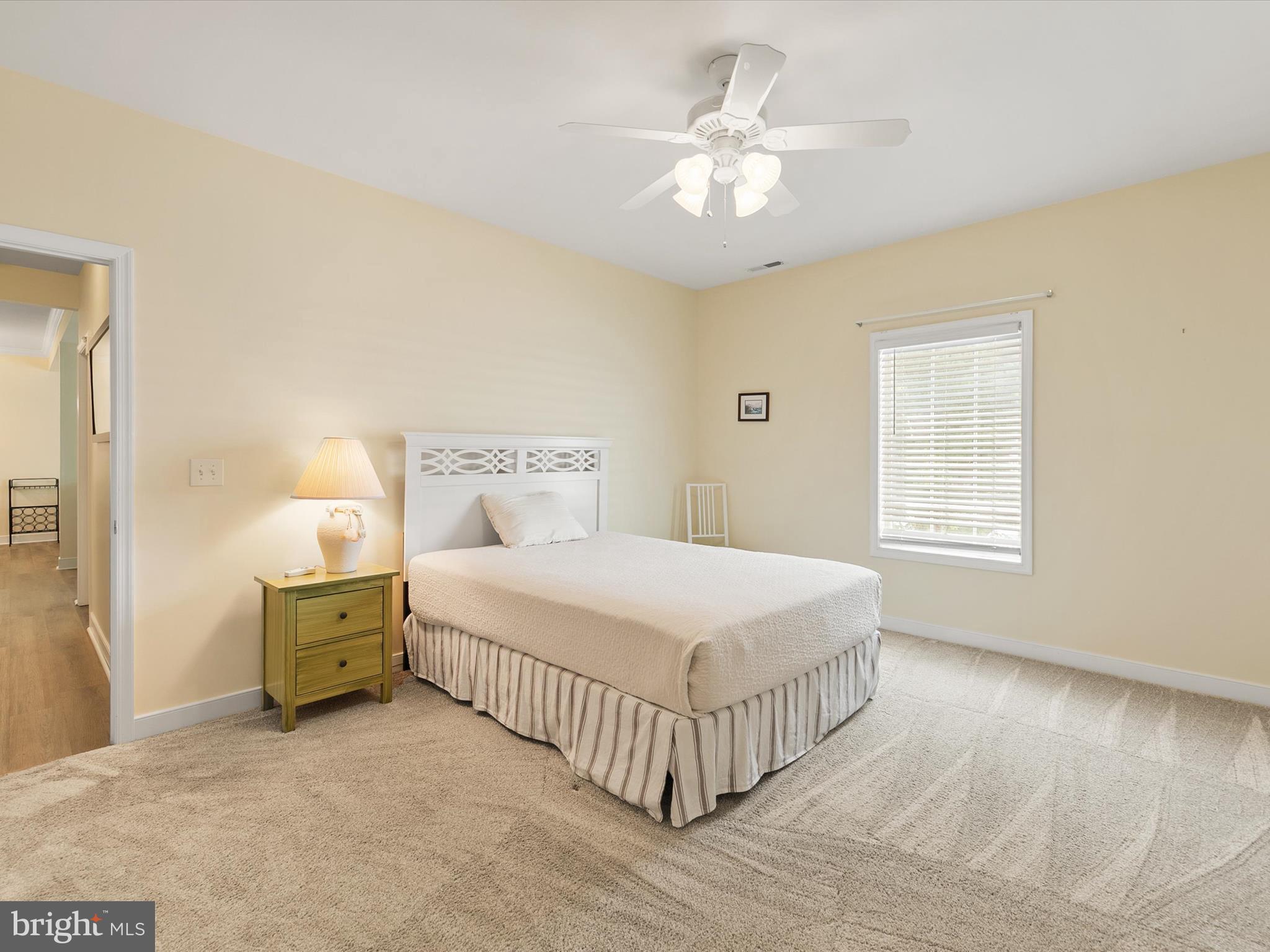 30611 Cedar Neck Road, Unit 2204 Ocean View, DE 19970 - Photo 16 of 33 a bedroom with a bed and a chandelier