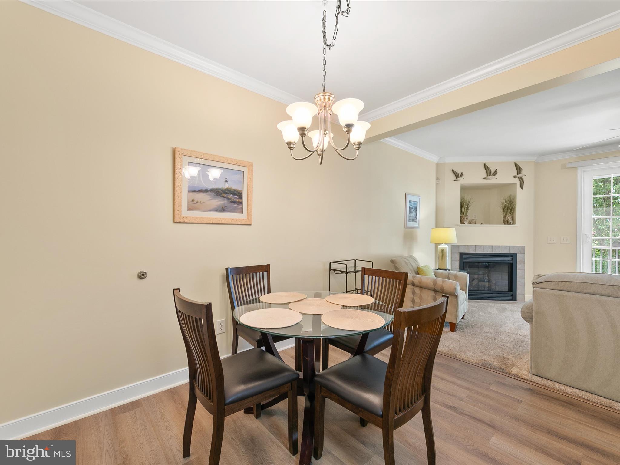 30611 Cedar Neck Road, Unit 2204 Ocean View, DE 19970 - Photo 9 of 33 a view of a dining room with furniture wooden floor and chandelier