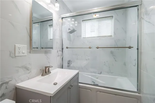 a bathroom with a sink mirror and a bathtub
