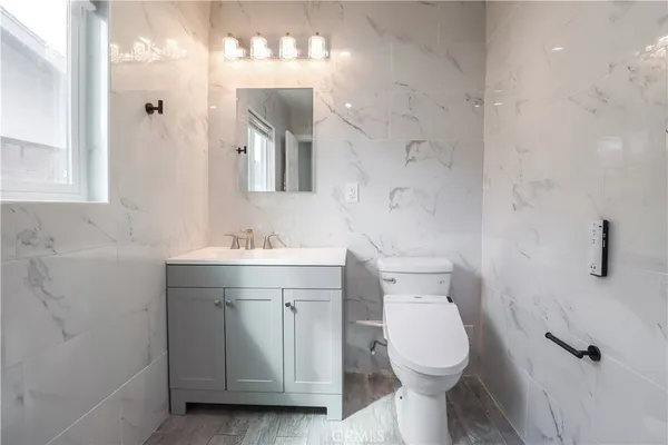 a bathroom with a toilet sink and mirror