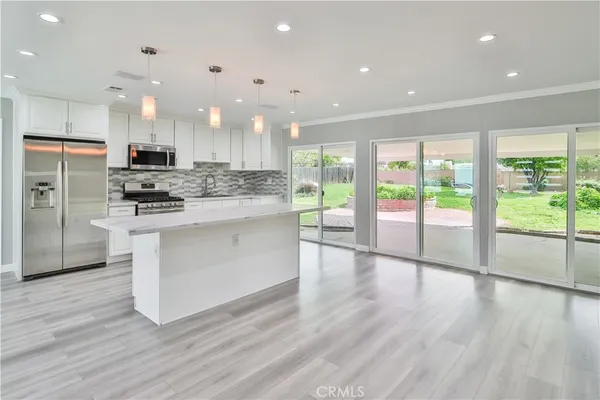 a kitchen with stainless steel appliances granite countertop a stove a sink and a refrigerator