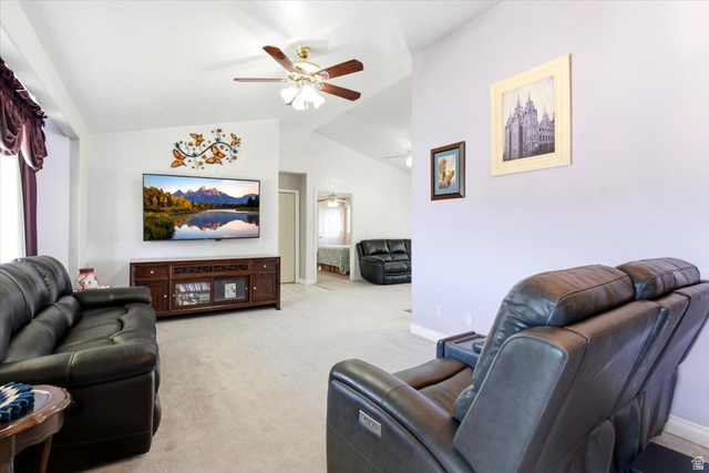 72 Canal Bank Road Garland, UT 84312 - Photo 6 of 40 Living room featuring vaulted ceilings, ceiling fan, neutral wall colors, wall-mounted television, and wood-finish media console