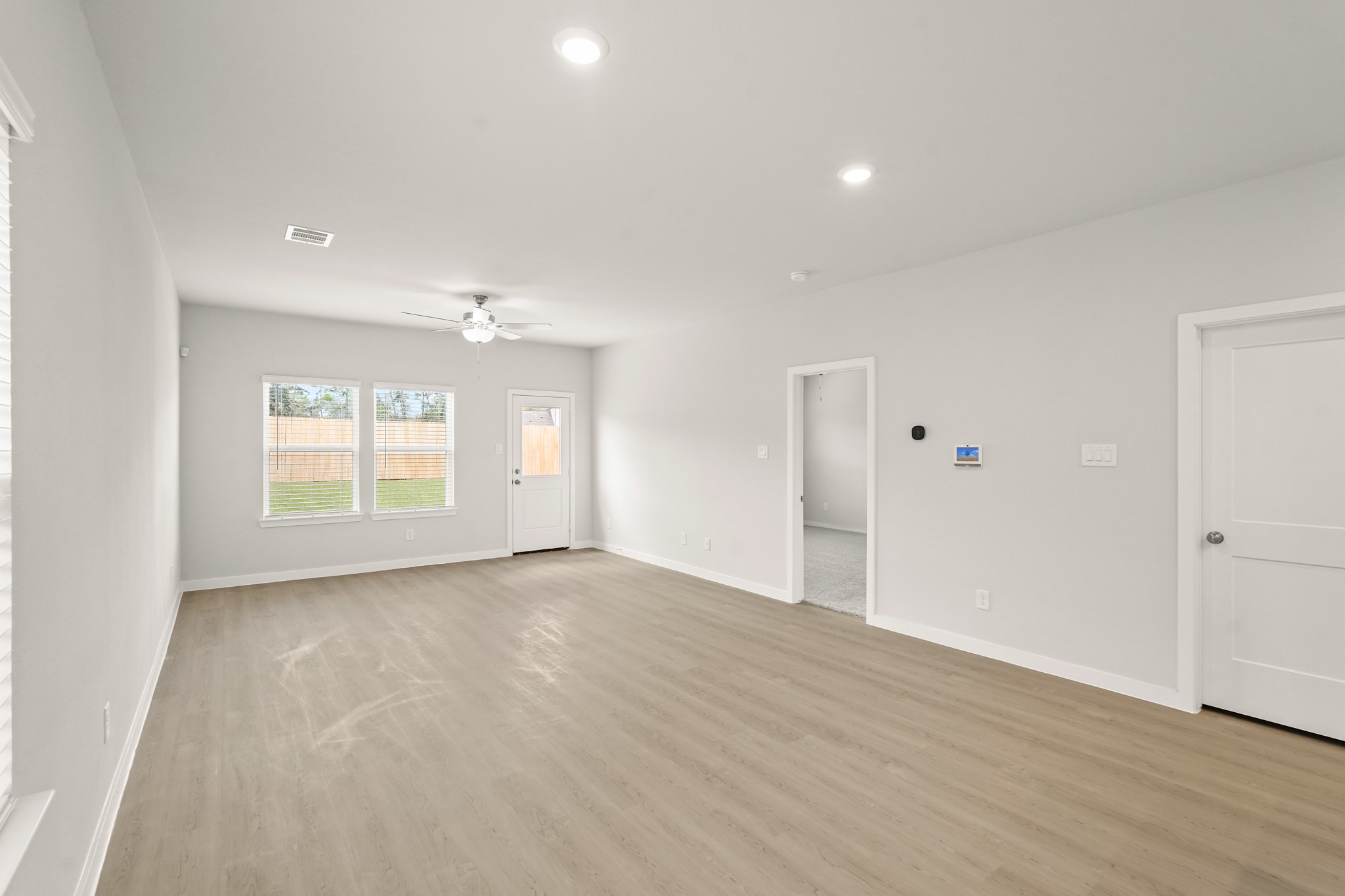 113 Rising Cedar Lane Hockley, TX 77447 - Photo 7 of 27 an empty room with wooden floor cabinet and windows