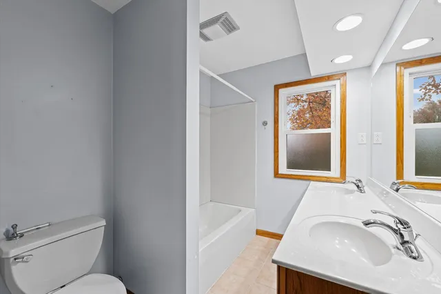 a view of a big room with wooden floor and windows