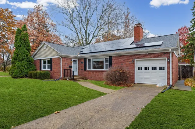 a front view of a house with a garden and yard