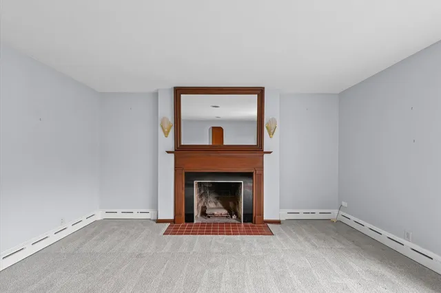 an empty room with wooden floor ceiling fan and windows