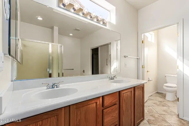 a bathroom with a double vanity sink toilet and a mirror