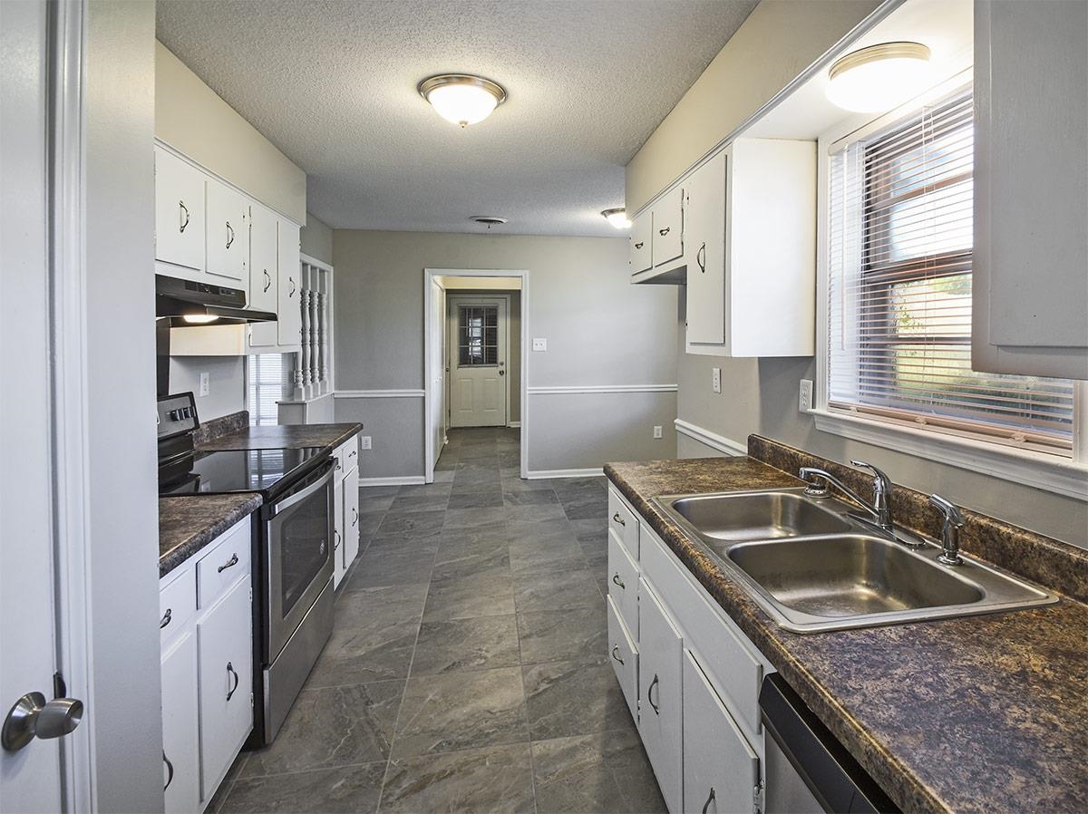 6731 Starkenburg Lane Memphis, TN 38115 - Photo 6 of 17 a kitchen that has a sink and a stove