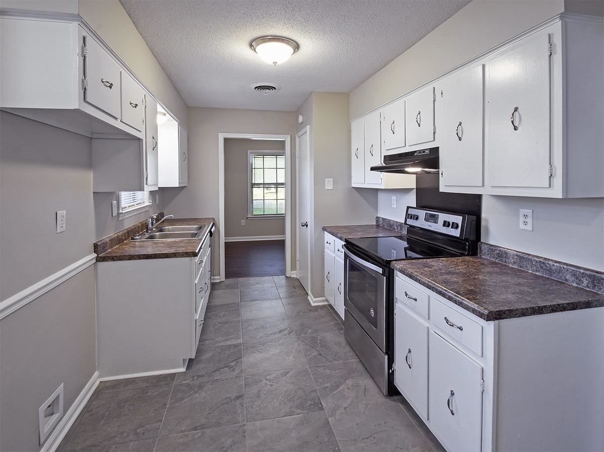 6731 Starkenburg Lane Memphis, TN 38115 - Photo 7 of 17 a kitchen with granite countertop a sink stove and refrigerator