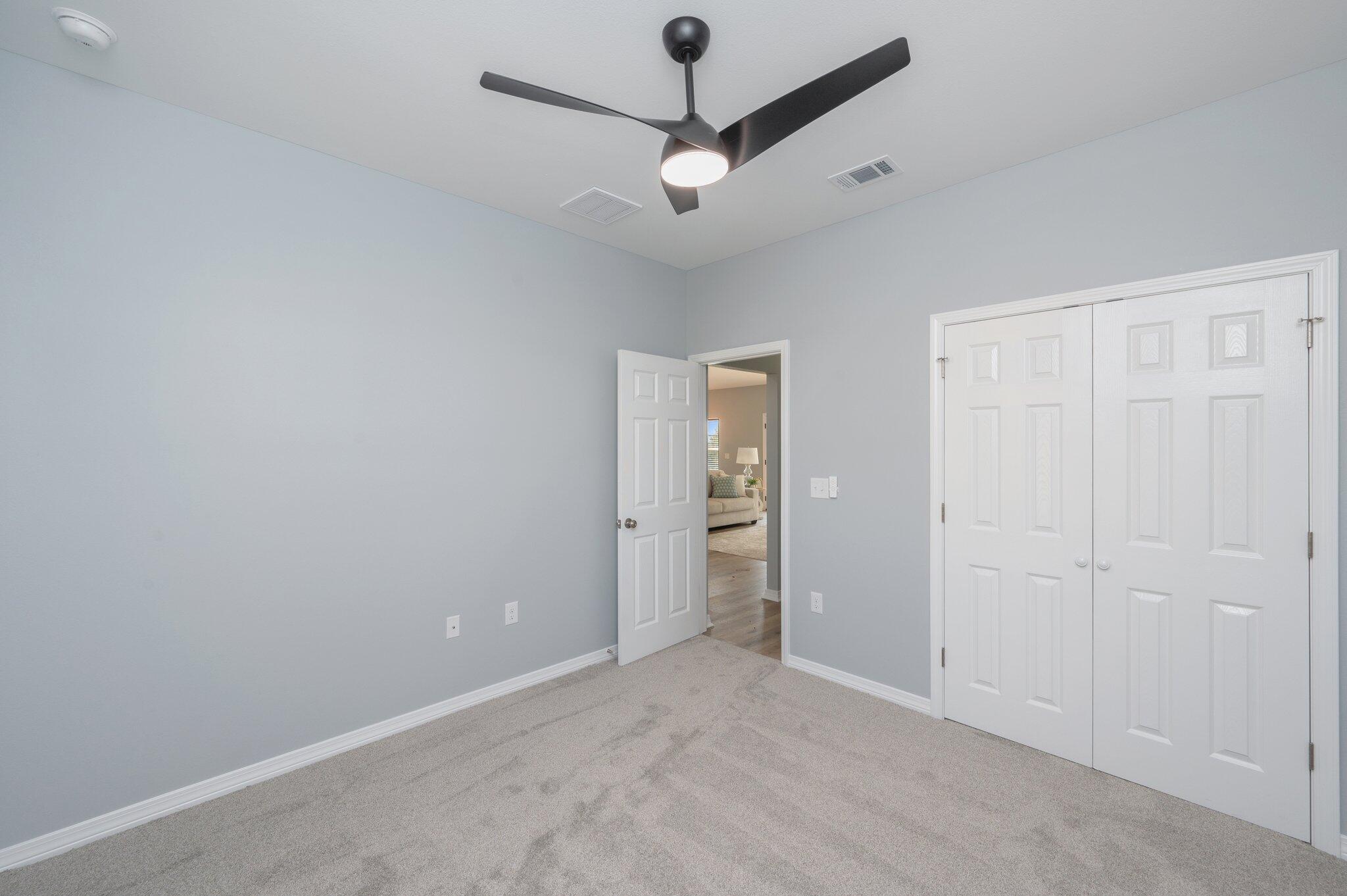 6010 Sand Hill Road Crestview, FL 32539 - Photo 30 of 33 an empty room with a ceiling fan and carpet