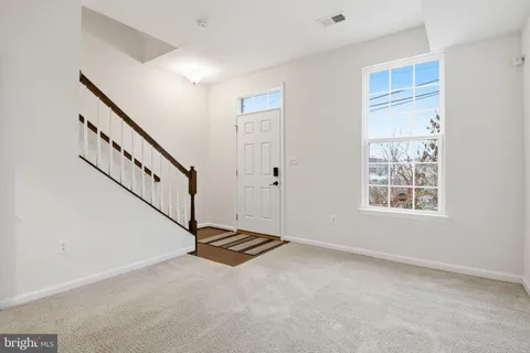 a view of a brick building with many windows and a yard