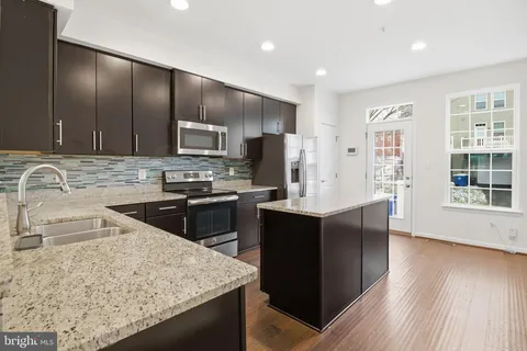 a kitchen with granite countertop stainless steel appliances and wooden cabinets