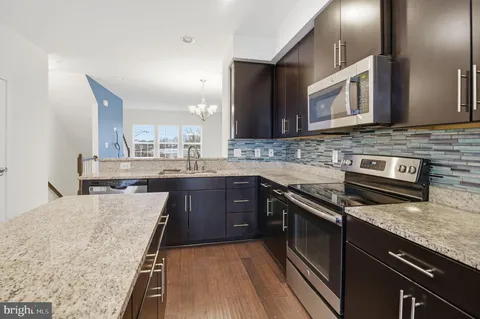 a kitchen with stainless steel appliances granite countertop a sink stove and microwave