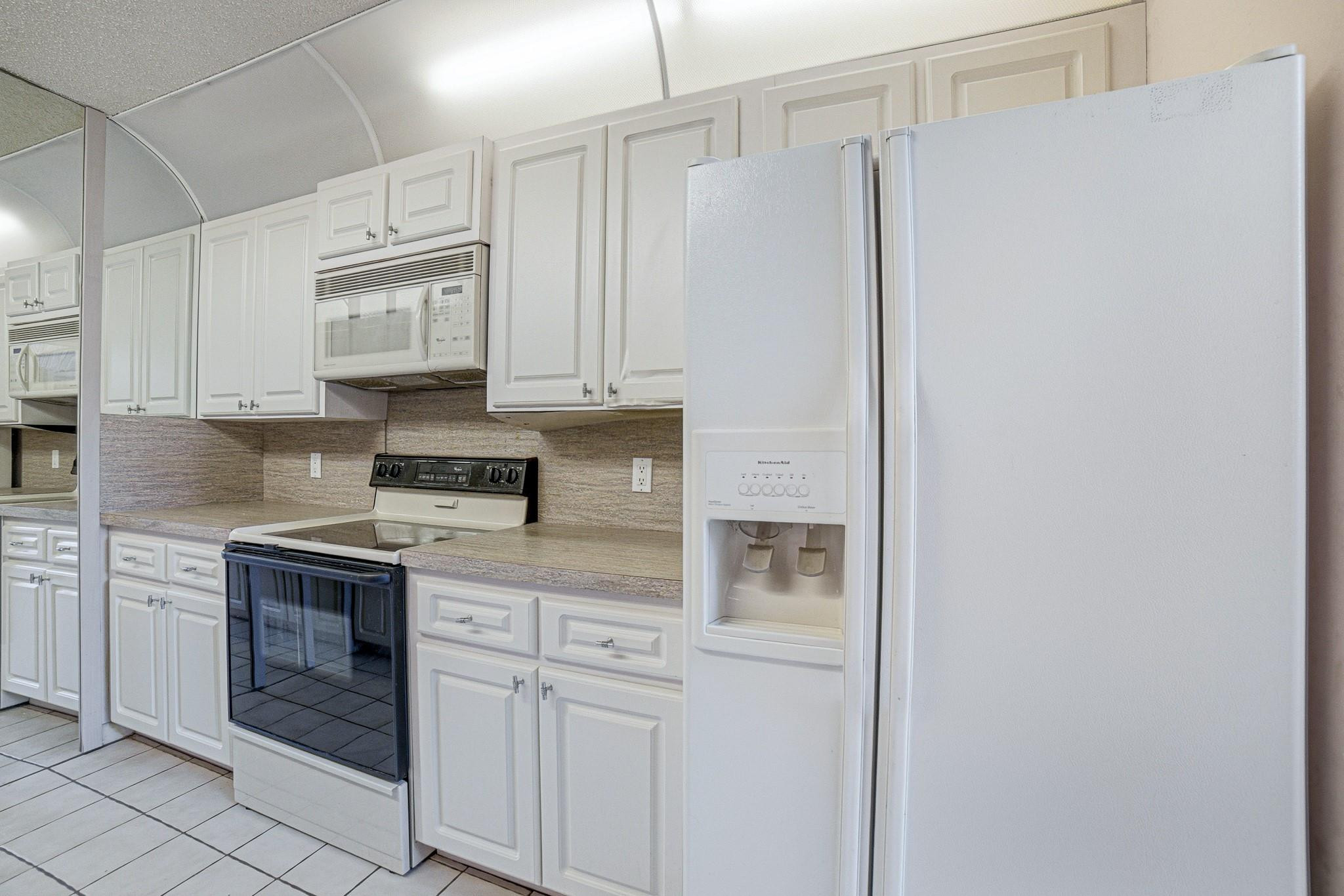 9101 Southwest 19th Place, Unit B Davie, FL 33324 - Photo 7 of 55 a kitchen with stainless steel appliances granite countertop white cabinets and white appliances