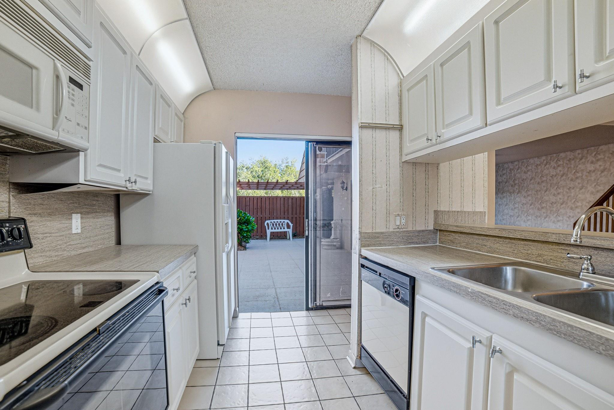 9101 Southwest 19th Place, Unit B Davie, FL 33324 - Photo 8 of 55 a kitchen with a sink stove and cabinets