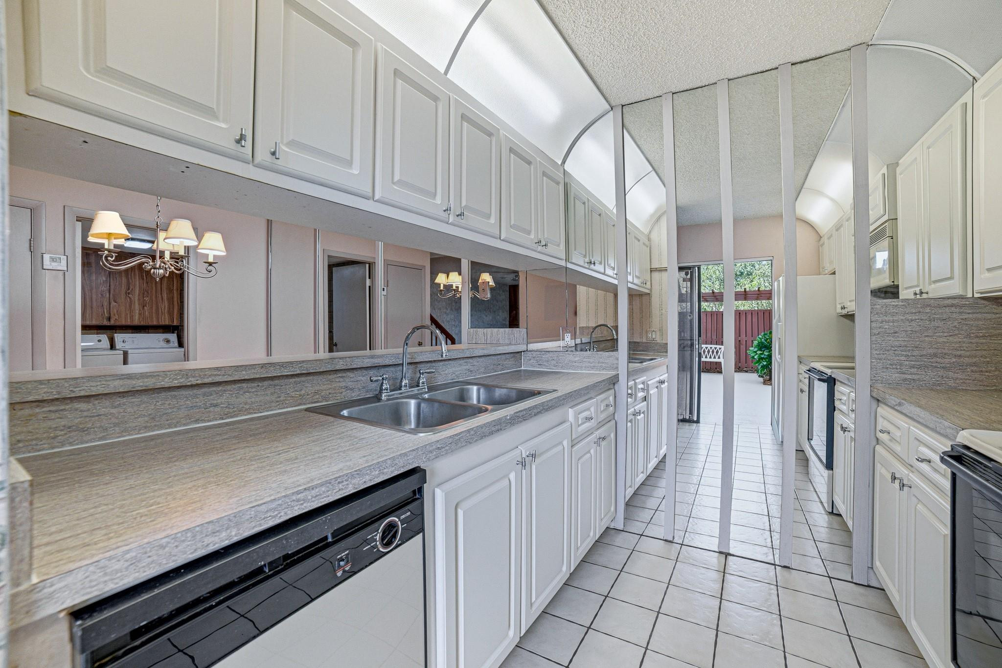 9101 Southwest 19th Place, Unit B Davie, FL 33324 - Photo 9 of 55 a kitchen with stainless steel appliances a sink stove and cabinets