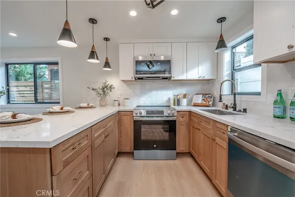 a kitchen with stainless steel appliances granite countertop a sink stove and cabinets