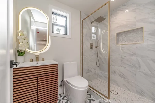 a bathroom with a sink a toilet and a mirror