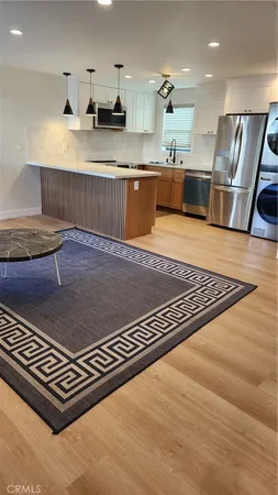 a open kitchen with stainless steel appliances granite countertop a refrigerator stove and sink