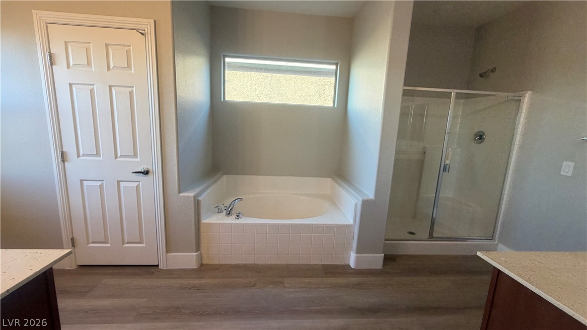 9453 Alma Ridge Avenue Las Vegas, NV 89178 - Photo 13 of 25 A well-appointed primary bathroom features a deep soaking tub and a spacious glass-enclosed shower.