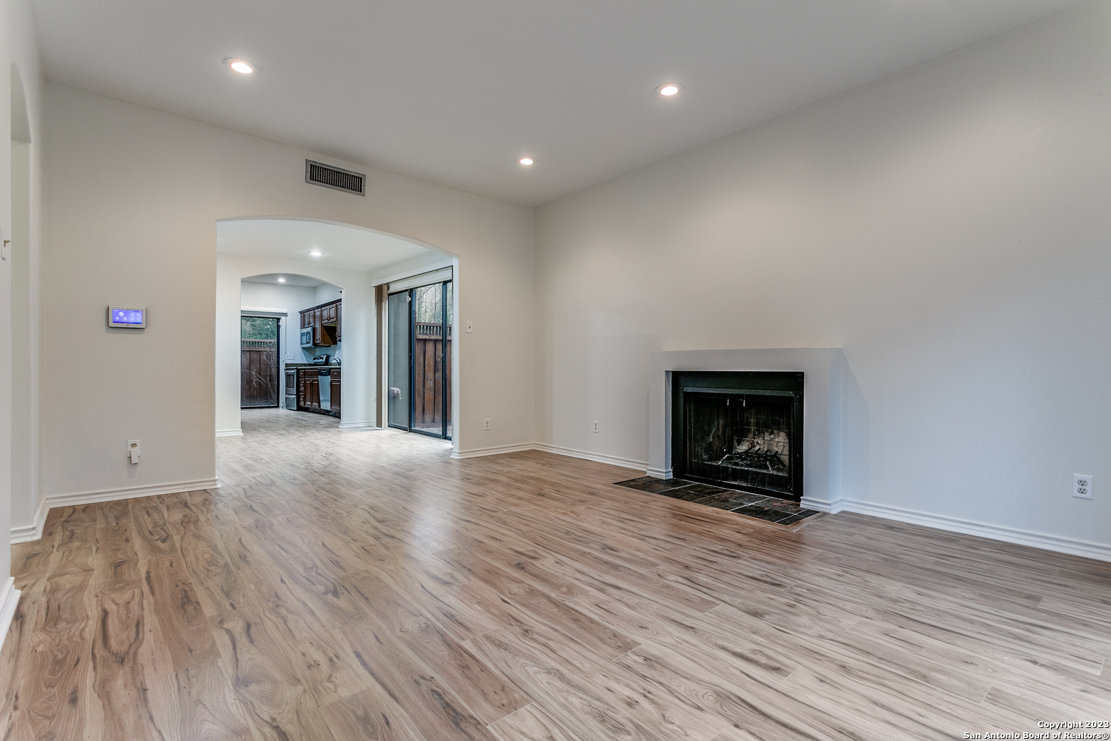 145 Terrell Road San Antonio, TX 78209 - Photo 3 of 12 an empty room with wooden floor and a fireplace