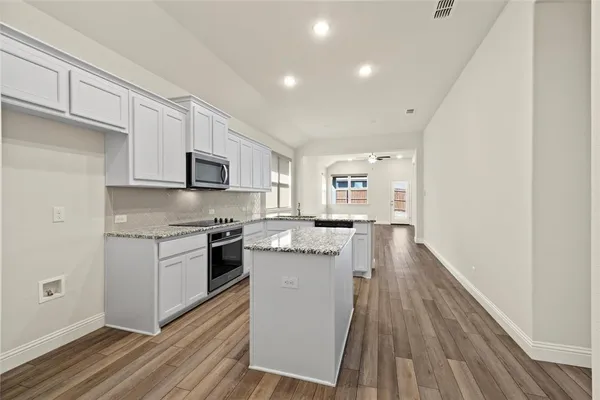 a kitchen with stainless steel appliances granite countertop a refrigerator a stove top oven a sink and dishwasher
