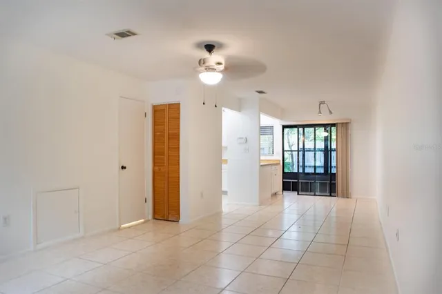 a view of an empty room with a kitchen and a window
