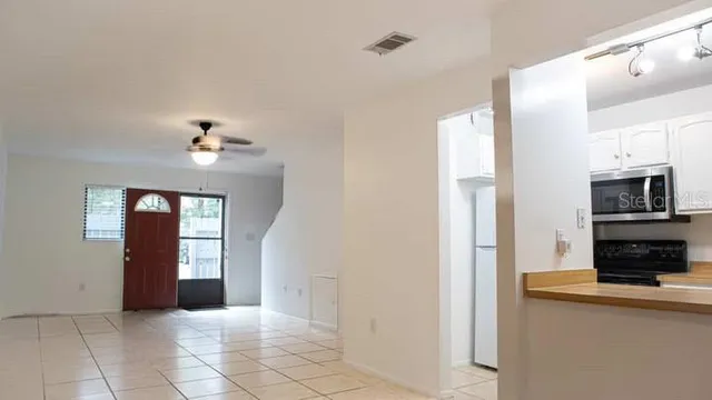 a view of a kitchen with white cabinets and a window