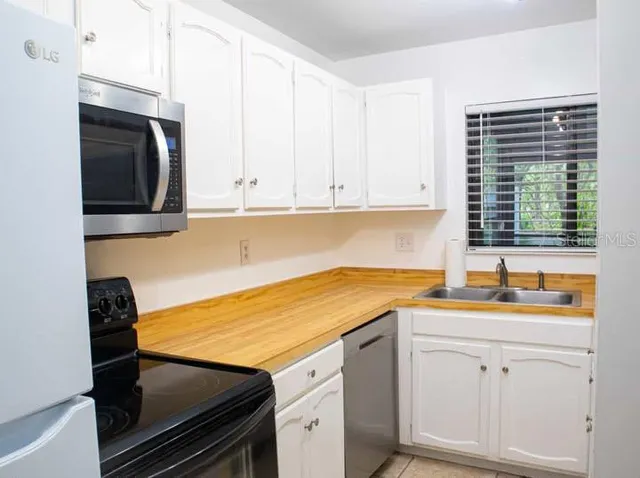 a kitchen with kitchen island a counter top space a sink and appliances