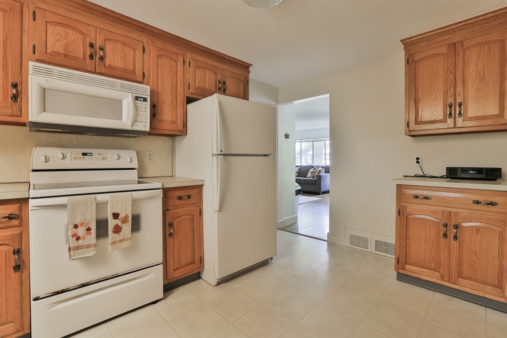 27 Gleason Road Reading, MA 01867 - Photo 17 of 28 a kitchen with stainless steel appliances granite countertop a refrigerator sink stove and white cabinets