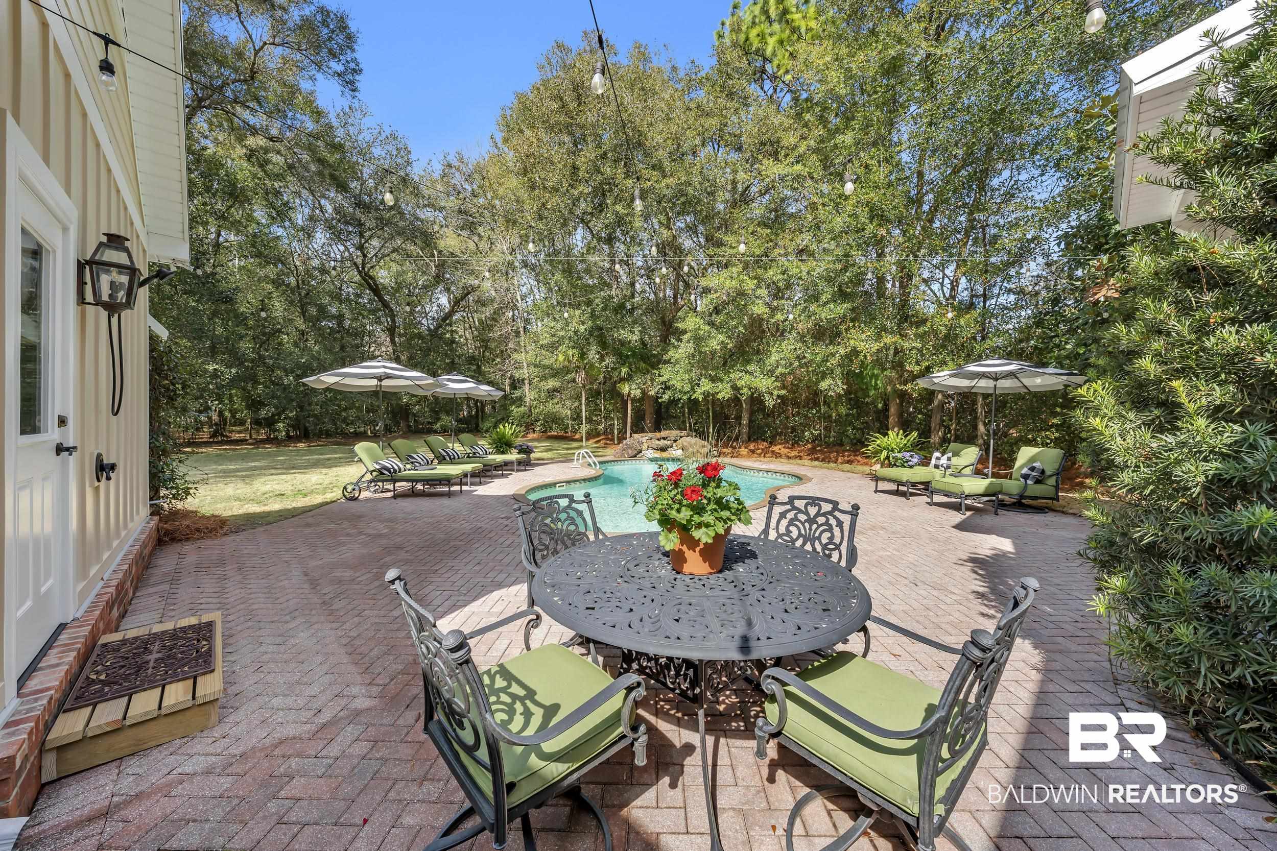 12161 Jessamine Street Magnolia Springs, AL 36555 - Photo 47 of 70 View of patio with an outdoor pool, outdoor dining area, and view of scattered trees