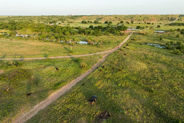 an aerial view of residential houses with outdoor space and trees