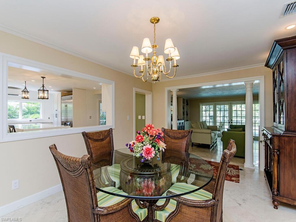 745 Pectin Road Naples, FL 34102 - Photo 11 of 18 a dining room with furniture a large window and wooden floor